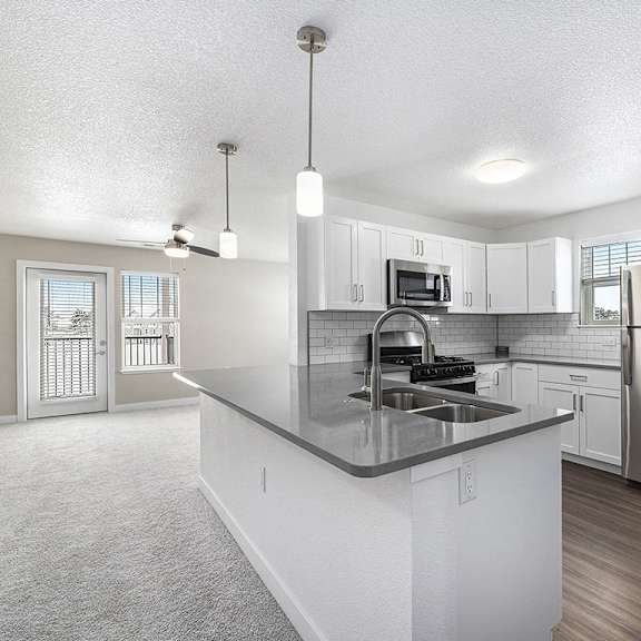 Thumbnail 4 of 15 A kitchen with a stainless steel refrigerator and a sink at Eagle Ridge Apartment Homes, Traverse City