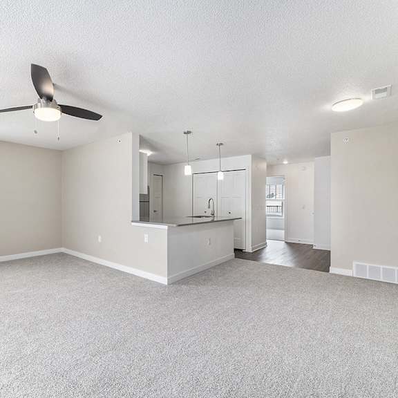 Thumbnail 9 of 15 A spacious living room with a ceiling fan and a window at Eagle Ridge Apartment Homes, Traverse City