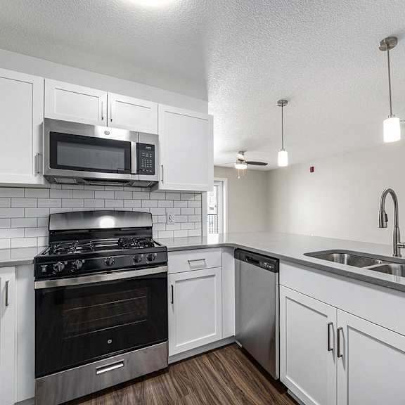 Thumbnail 9 of 14 A kitchen with a stove, oven, microwave, and sink at Eagle Ridge Apartment Homes, Traverse City, Michigan
