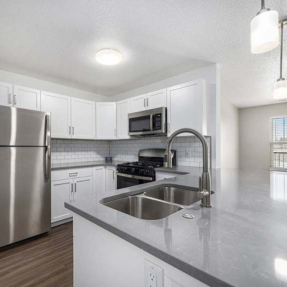 Thumbnail 8 of 14 A kitchen with a stainless steel refrigerator and a sink at Eagle Ridge Apartment Homes, Traverse City, Michigan
