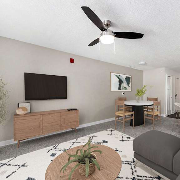 Thumbnail 6 of 14 A living room with a grey couch, a wooden coffee table, and a ceiling fan at Eagle Ridge Apartment Homes, Traverse City, MI 49685