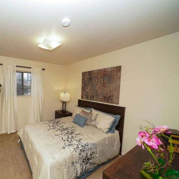 Thumbnail 9 of 10 A large bedroom with a window and a closet at Emerald Park Apartments, Kalamazoo, MI