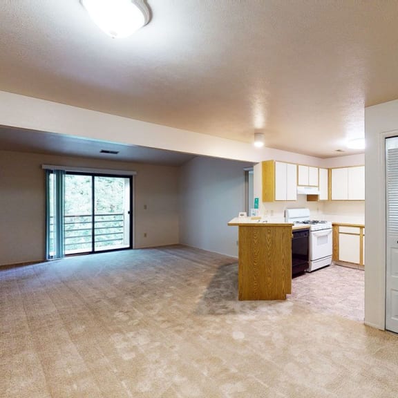 Thumbnail 4 of 10 A dining and living room with a slider to a balcony at Emerald Park Apartments, Kalamazoo, MI, 49001