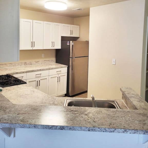 Thumbnail 7 of 10 an upgraded kitchen with white cabinets and a breakfast bar at Emerald Park Apartments in Kalamazoo, 49001