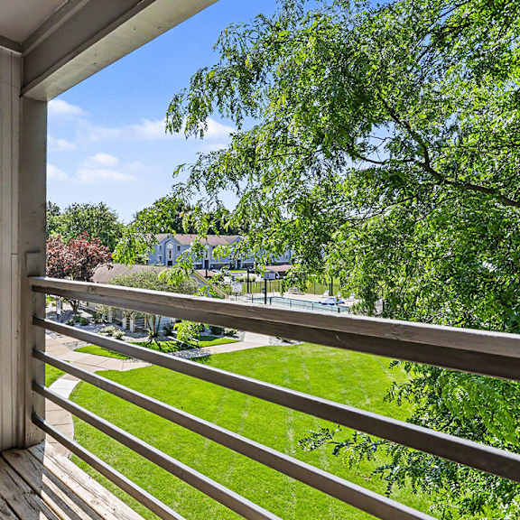 Thumbnail 5 of 17 A balcony with a view of a green lawn at Emerald Park Apartments, Kalamazoo, Michigan