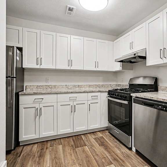 Thumbnail 7 of 17 A kitchen with white cabinets and stainless steel appliances at Emerald Park Apartments, Kalamazoo, Michigan
