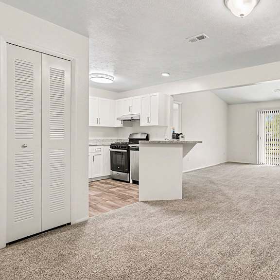 Thumbnail 3 of 17 A kitchen with white cabinets and a sliding glass door to a balcony at Emerald Park Apartments, Kalamazoo, Michigan