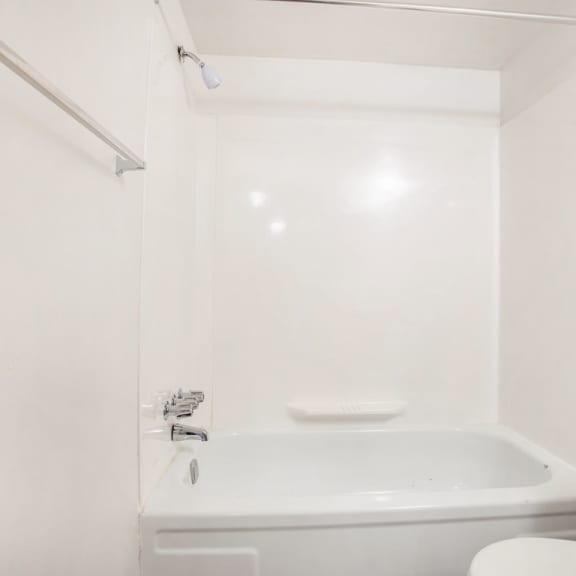 Thumbnail 14 of 17 a white bathroom with a tub and a toilet at Fairlane Apartments in Michigan 49037