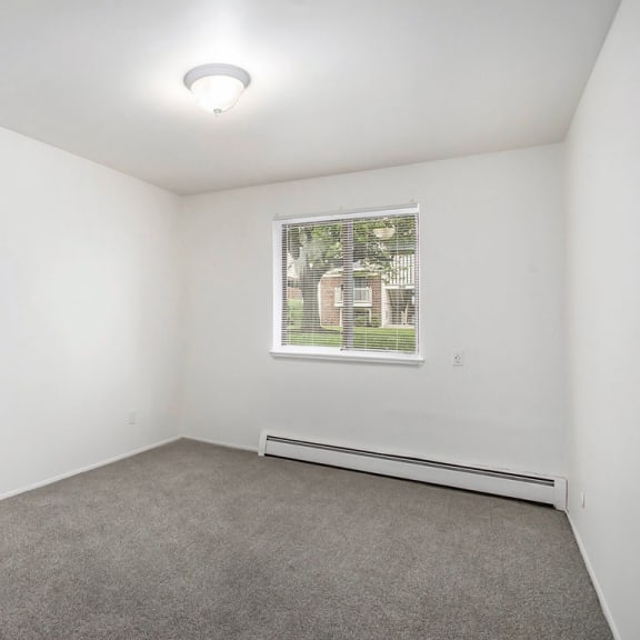 Thumbnail 17 of 17 carpeted bedroom with a window at Fairlane Apartments in Springfield, Michigan
