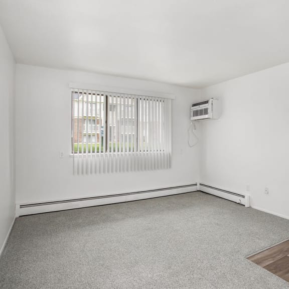 Thumbnail 6 of 17 an empty living room with a large window at Fairlane Apartments in Springfield, 49037
