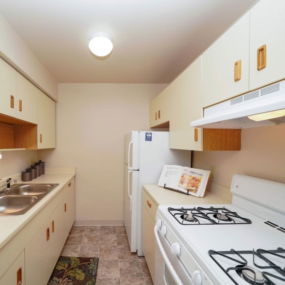 Thumbnail 8 of 13 a kitchen with a stove and refrigerator and a sink