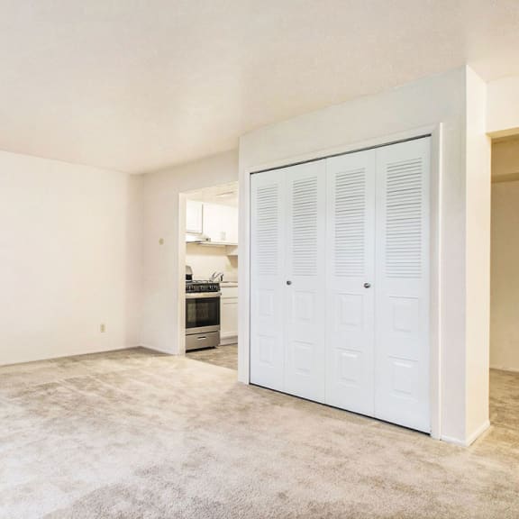 Thumbnail 10 of 12 an empty living room with a door to the kitchen at Old Farm Apartments, Elkhart, 46517