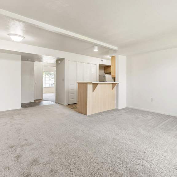 Thumbnail 4 of 7 A large, empty living room with a carpeted floor at Fieldstream Apartment Homes, Iowa