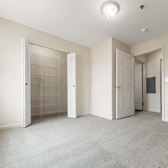 Thumbnail 11 of 11 A bedroom with a carpeted floor and a walk-in closet with organizers at Fieldstream Apartment Homes in IA 50023