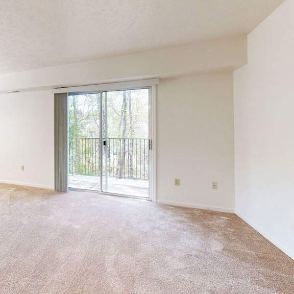 Thumbnail 3 of 8 an enlarged living room with a sliding glass door to a balcony at Fieldstream Apartment Homes, Iowa