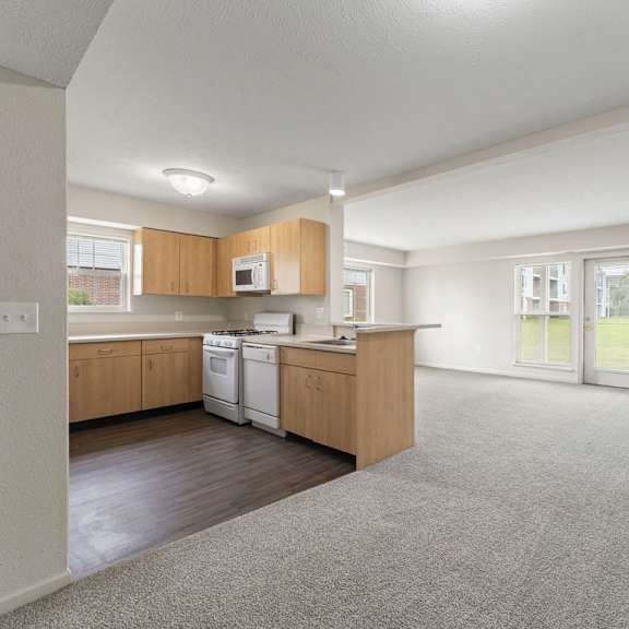 Thumbnail 3 of 11 A kitchen with wooden cabinets and a white dishwasher at Fieldstream Apartment Homes in IA 50023