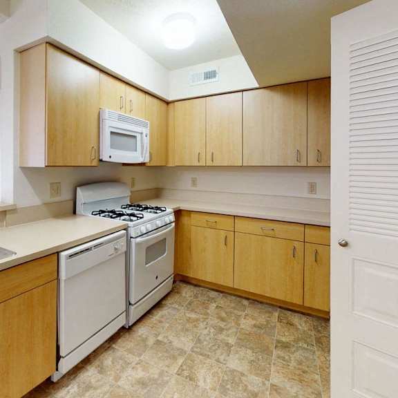 Thumbnail 5 of 9 a kitchen with white appliances and wooden cabinets at Fieldstream Apartment Homes, Iowa