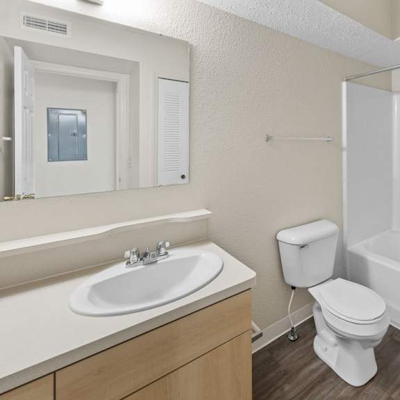 Thumbnail 11 of 18 A bathroom with a toilet, sink, and bathtub at Fieldstream Apartment Homes, Iowa