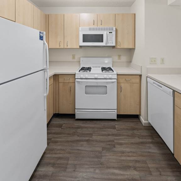 Thumbnail 7 of 18 A kitchen with a white refrigerator, microwave, stove, and dishwasher at Fieldstream Apartment Homes, Iowa