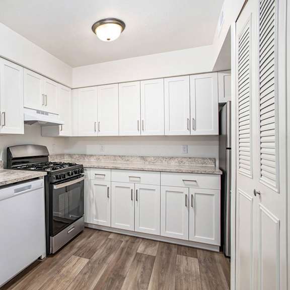 Thumbnail 6 of 11 A kitchen with white cabinets and hard-surface flooring at Foxwood and The Hermitage in Portage, MI