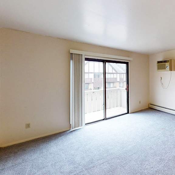 Thumbnail 5 of 12 A living room with plush carpet at Glen Oaks Apartments, Michigan, 49442