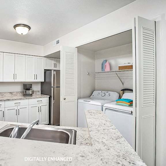 Thumbnail 9 of 16 a kitchen with a washer and dryer at Glenn Valley Apartments in Battle Creek, MI