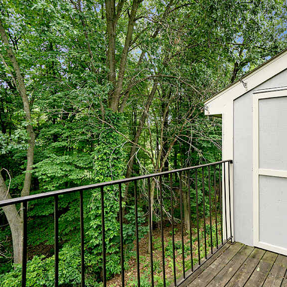 Thumbnail 4 of 13 A private balcony with a black railing and enclosed storage at Glenn Valley Apartments, Battle Creek, MI, 49015