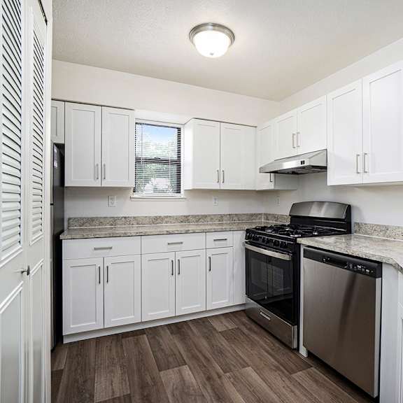 Thumbnail 7 of 13 A kitchen with a window and white cabinets at Glenn Valley Apartments, Battle Creek, MI, 49015