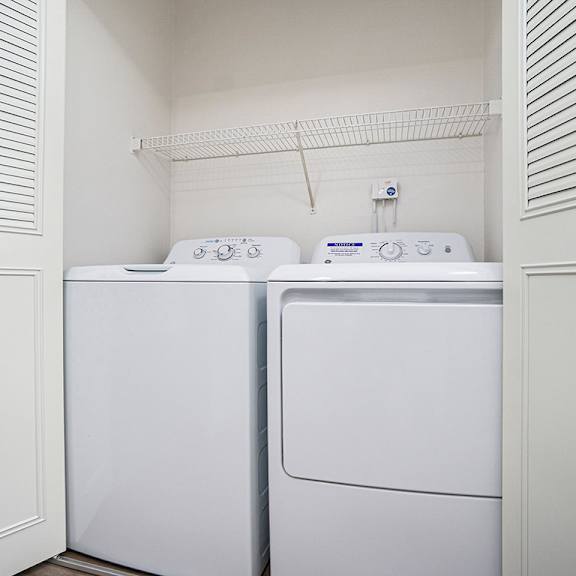 Thumbnail 9 of 13 A full-size washer and dryer in a small laundry room at Glenn Valley Apartments, Battle Creek, MI, 49015