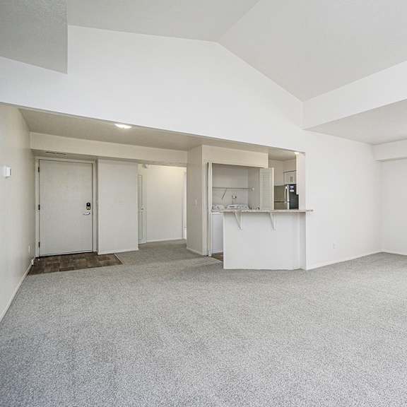Thumbnail 5 of 13 End style living room with a cathedral ceiling and carpet at Glenn Valley Apartments, Battle Creek, MI, 49015