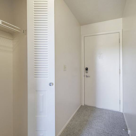 Thumbnail 5 of 14 An entry closet with a white door in a room with white walls at Glenn Valley Apartments, Michigan, 49015