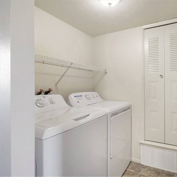 Thumbnail 10 of 14 A small laundry room with a washer and dryer at Glenn Valley Apartments, Michigan, 49015
