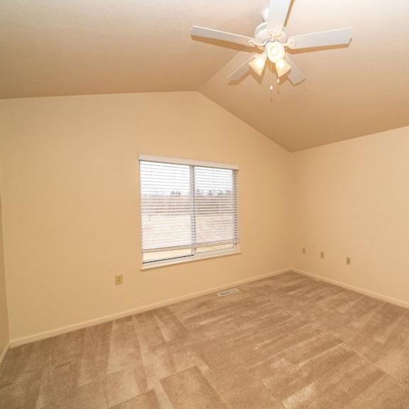 Thumbnail 20 of 28 an empty bedroom with a ceiling fan and a window at Gull Prairie/Gull Run Apartments and Townhomes, Michigan, 49048