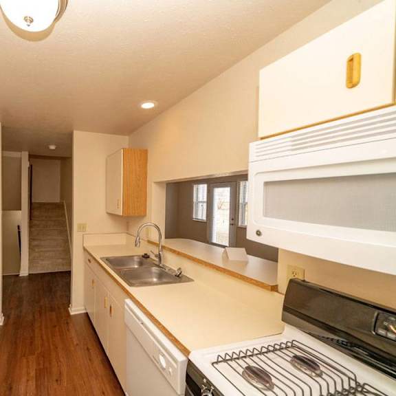 Thumbnail 9 of 28 an empty kitchen with a stove and a sink at Gull Prairie/Gull Run Apartments and Townhomes, Kalamazoo, MI, 49048