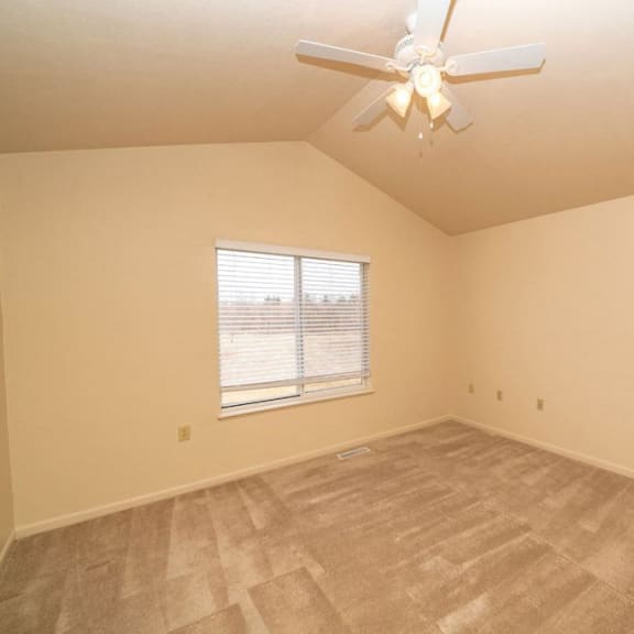 Thumbnail 10 of 11 an empty bedroom with a ceiling fan and a window at Gull Prairie/Gull Run Apartments and Townhomes, Michigan, 49048