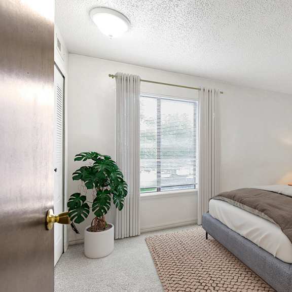 Thumbnail 10 of 10 A bedroom with a large window, bed, and a plant at Granada Apartments, Jackson, 49202