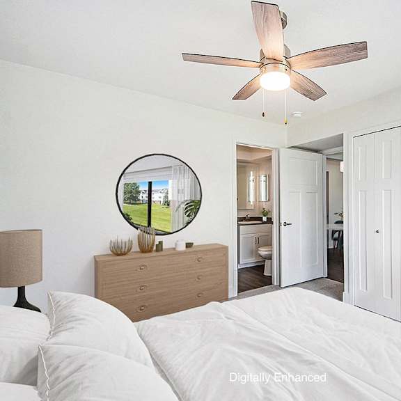 Thumbnail 13 of 14 A bedroom with an ensuite, a bed, dresser, mirror, and a ceiling fan at Green Ridge Apartments, Grand Rapids, 49544