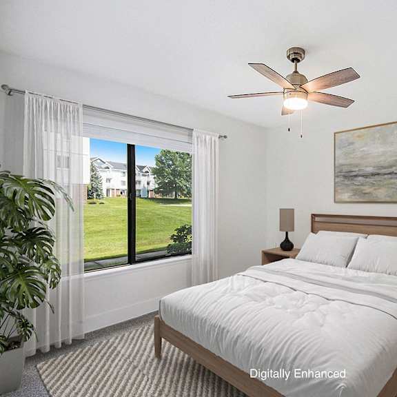 Thumbnail 11 of 14 A bedroom with a large bed, a ceiling fan, and a window at Green Ridge Apartments, Grand Rapids, 49544