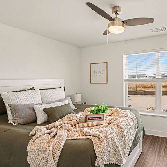 Thumbnail 18 of 19 A bedroom with a bed, large windows and a ceiling fan at The Grove Apartment Homes, Nebraska