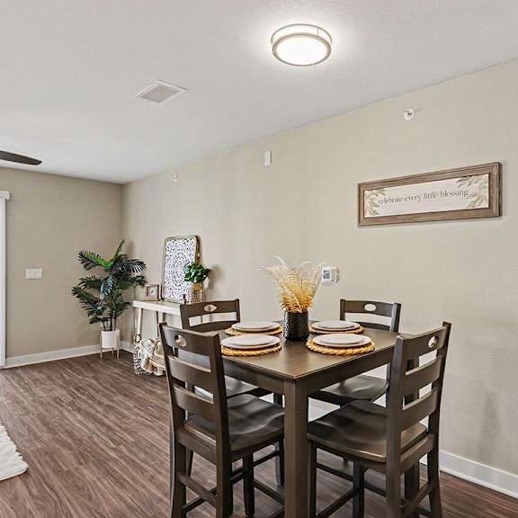 Thumbnail 9 of 19 A dining room with a table set for two and a hard-surface floor at The Grove Apartment Homes, Nebraska