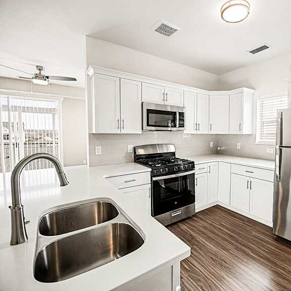 Thumbnail 6 of 13 A modern kitchen with stainless steel appliances and white cabinets at The Grove Apartment Homes in Lincoln, NE