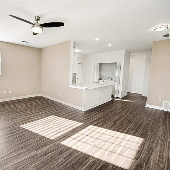 Thumbnail 5 of 13 An end style living room with a ceiling fan and a window at The Grove Apartment Homes in Lincoln, NE