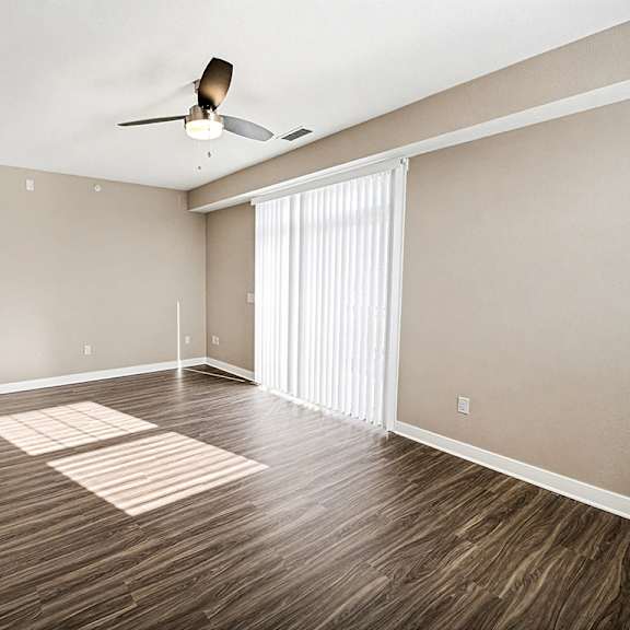 Thumbnail 4 of 13 A living room with a ceiling fan and hard-surface flooring at The Grove Apartment Homes in Lincoln, NE