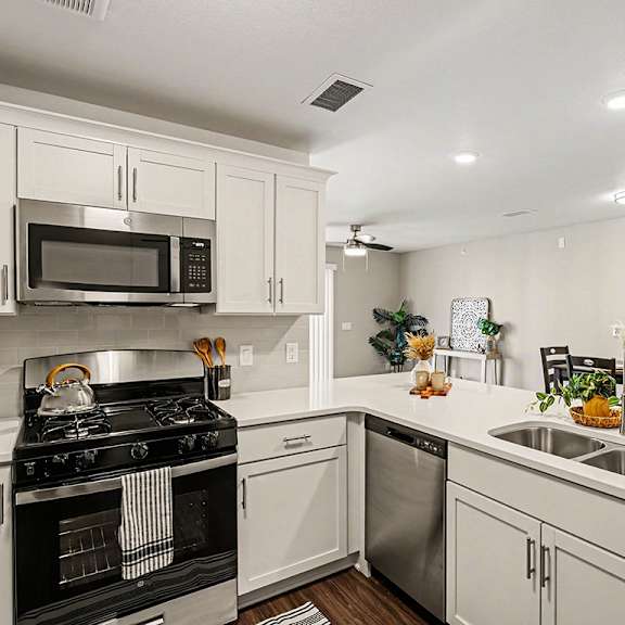 Thumbnail 11 of 19 A modern kitchen with white cabinets and a breakfast bar at The Grove Apartment Homes, Nebraska