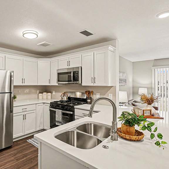 Thumbnail 10 of 19 A kitchen with white shaker-style cabinets and stainless steel appliances at The Grove Apartment Homes in Lincoln, NE
