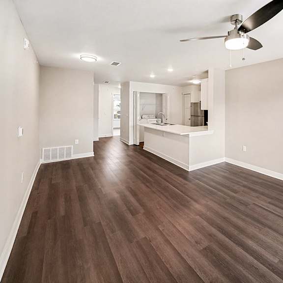 Thumbnail 8 of 19 A living room with a ceiling fan and hard-surface flooring at The Grove Apartment Homes in Lincoln, NE