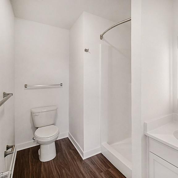 Thumbnail 13 of 14 A second bathroom with a toilet, sink, and a shower at The Grove Apartment Homes in Lincoln, NE