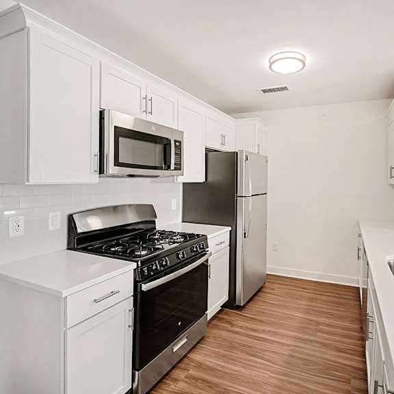 Thumbnail 6 of 14 A kitchen with white, shaker-style cabinets and stainless steel appliances at The Grove Apartment Homes in Lincoln, NE