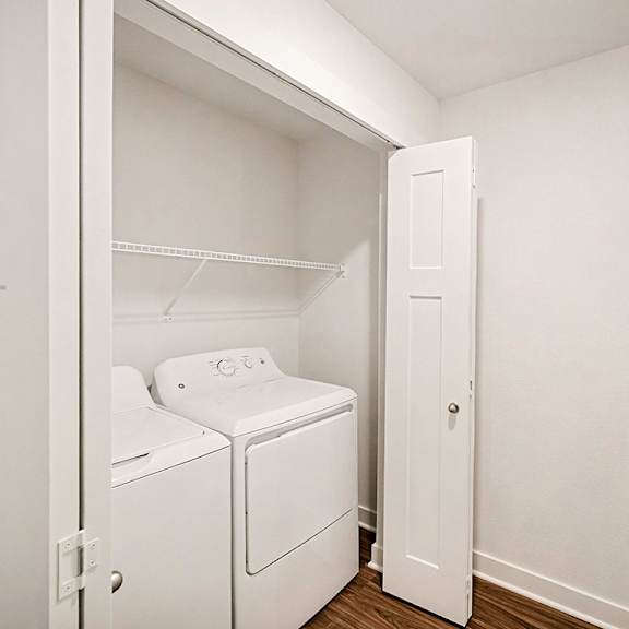 Thumbnail 8 of 14 A full-size washer and dryer with a shelf above at The Grove Apartment Homes in Lincoln, NE