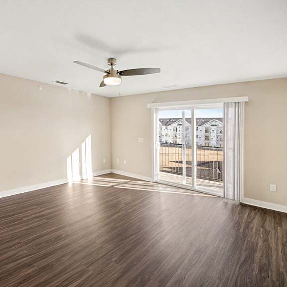 Thumbnail 4 of 14 A living room with a ceiling fan and hard-surface floors at The Grove Apartment Homes in Lincoln, NE